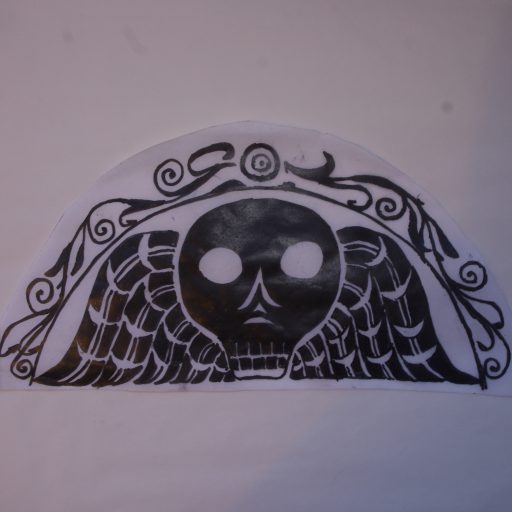 A black drawing of gravestone art of a skull with wings, on a white background.